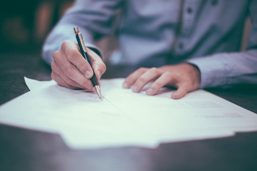 Signing paperwork at a desk, illustrating a closed property transaction