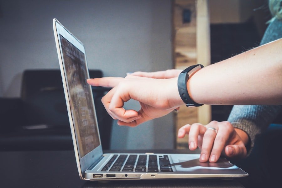 A finger touching a laptop screen, illustrating interaction responsiveness