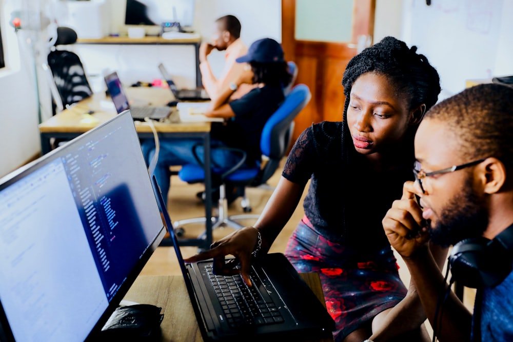 Two specialists reviewing search performance data on a monitor